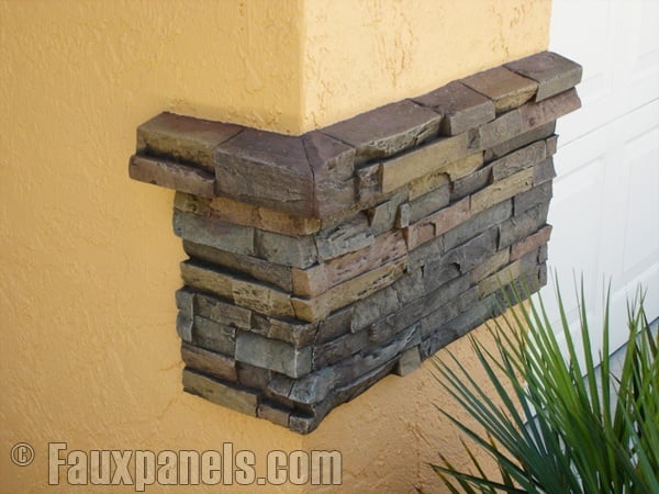 An exposed stone wall look created on a home's exterior with a few panel pieces and a ledger.