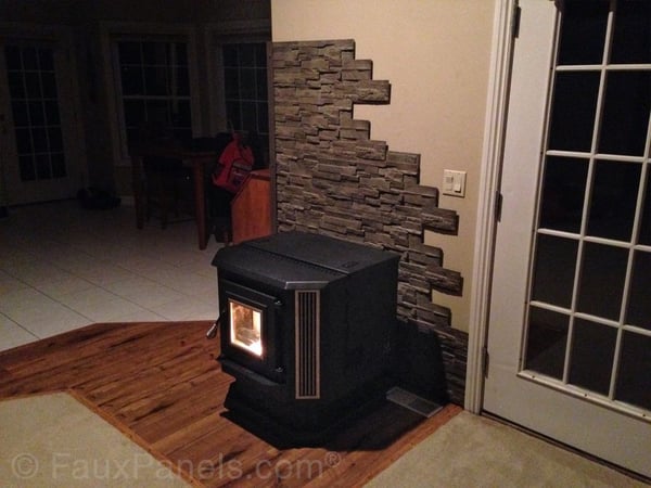 Fire-rated panels behind a wood stove cut to look like a real exposed stone wall.