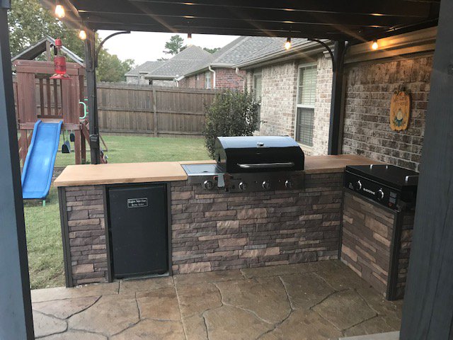 Outdoor patio kitchen finished with Nailon Stone Wall Plus siding in Sedona Buff.