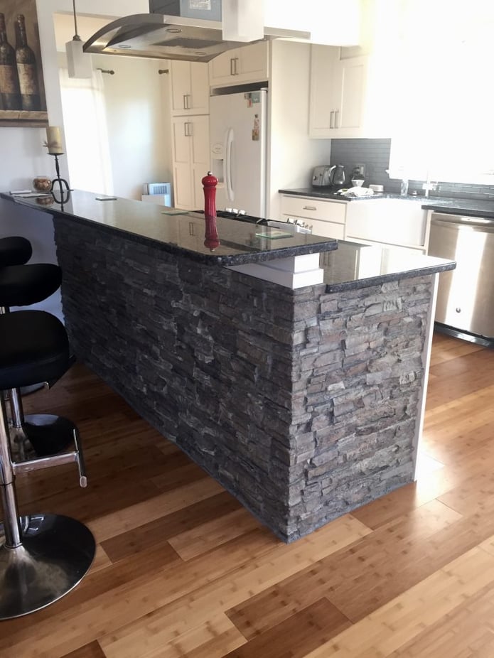 Kitchen breakfast bar covered in faux stacked stone.