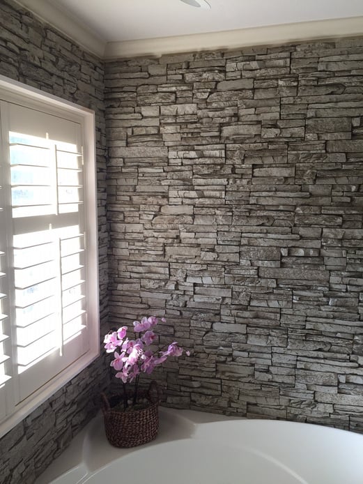 Gorgeous bathtub wall surround created with Norwich Stacked Stone panels in a light gray color.